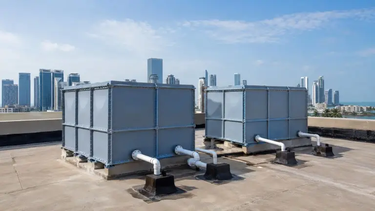 FRP water storage tanks on commercial building rooftop — building water supply system