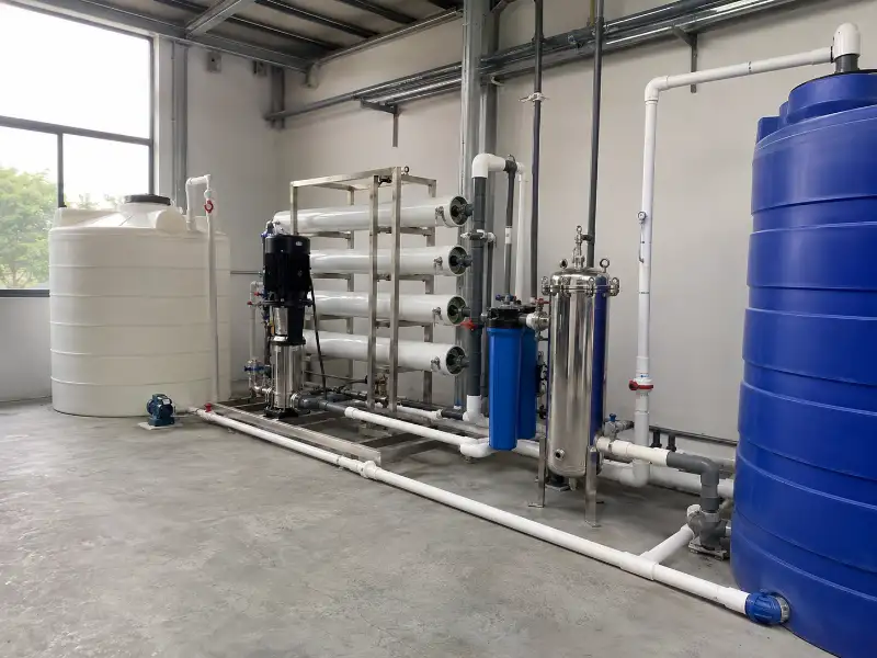 Installed reverse osmosis water treatment components with feed tank, high-pressure pump, cartridge filter, and product water tank in a plant room